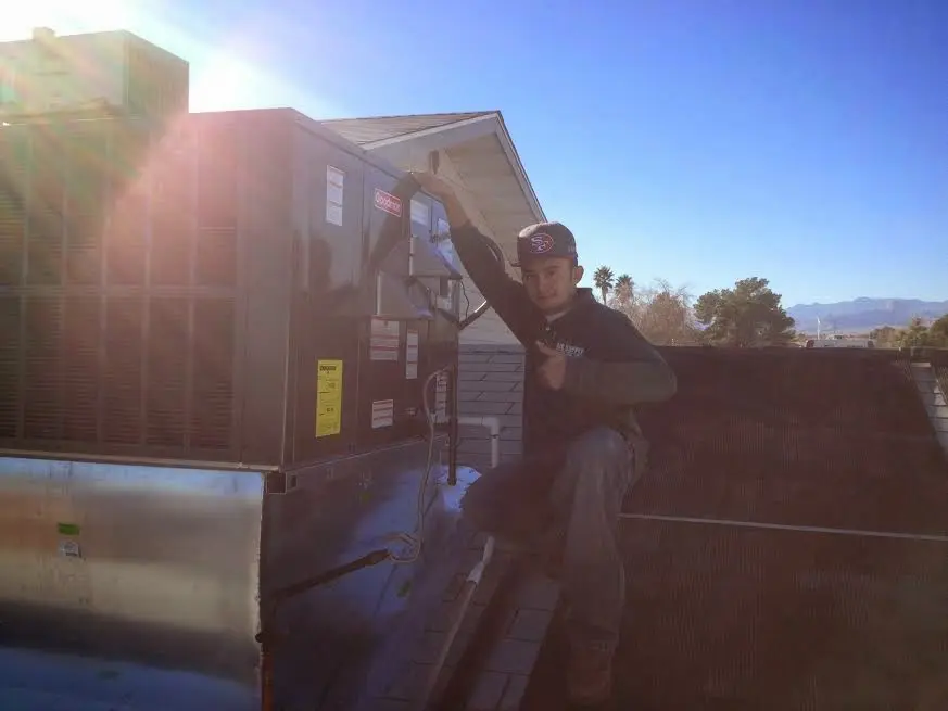 HVAC technician performing HVAC Inspection on a rooftop unit in Wooster